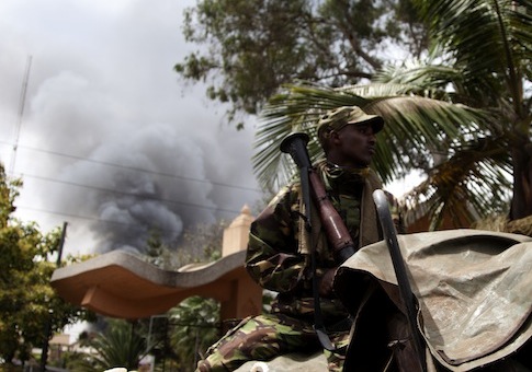 A soldier  holds a RPG near the Westgate shopping mall in Nairobi, Kenya, as smoke rises from it / AP