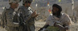 A U.S. soldier with an Afghan interpreter speaking to a local man / AP