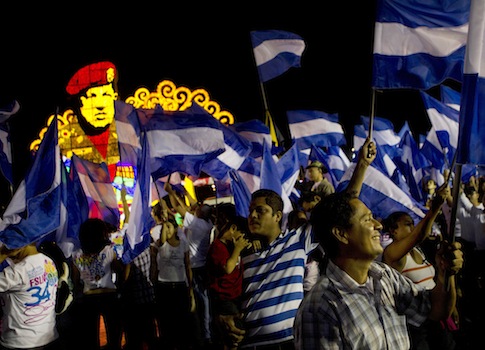 Sandinista supporters hold Nicaraguan flags in ceremony honoring Hugo Chavez in Managua, Nicaragua / AP