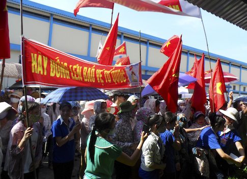 Workers wave Vietnamese national flags during an anti-China protest / REUTERS