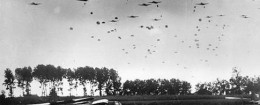 American paratroopers drop from a fleet of carrier planes to land near Grave in the Netherlands in 1944 during World War II. In the foreground, left, are gliders which have already landed with airborne troops.