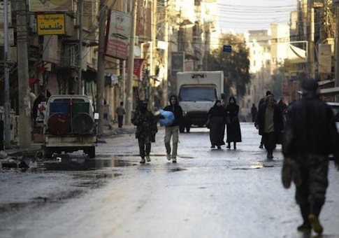 Free Syrian Army fighters walk along a street in Deir al-Zor, eastern Syria, Dec. 12, 2013