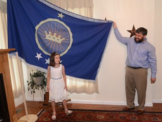 Jeremiah Heaton and his seven year-old daughter, Princess Emily, show the flag