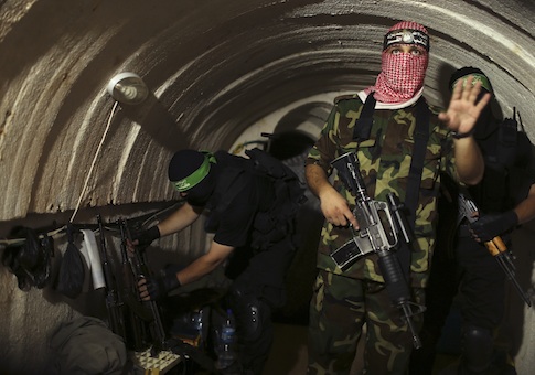 A Palestinian fighter from the Izz el-Deen al-Qassam Brigades, the armed wing of the Hamas movement, gestures inside an underground tunnel in Gaza August 18