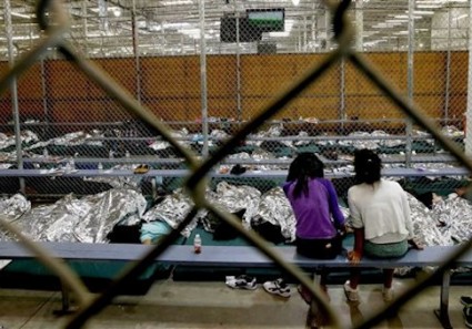 two young girls watch a World Cup soccer match on a television from their holding area where hundreds of mostly Central American immigrant children are being processed and held