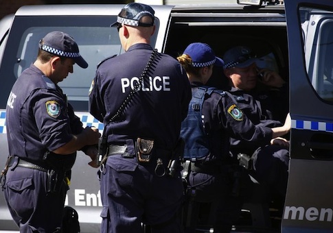 Police talk outside a house that was involved in pre-dawn raids in the western Sydney suburb of Guilford