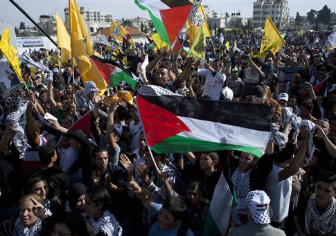 Palestinian supporters fly Palestinian and Fatah party flags, chant slogans and dance during a ceremony marking the 10th anniversary of the late Palestinian leader Yasser Arafat's death, at the Palestinian Authority headquarters, in the West Bank city of Ramallah