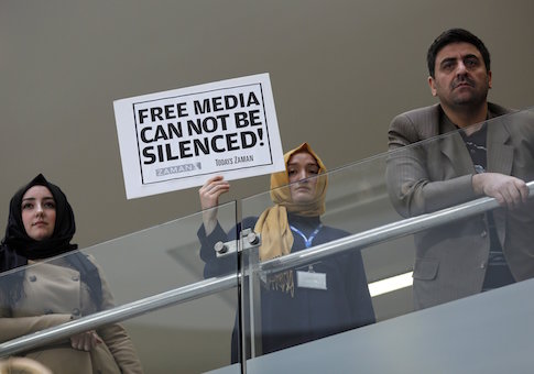 A Zaman journalist holds a placard at the headquarters of Zaman daily newspaper in Istanbul December 14, 2014