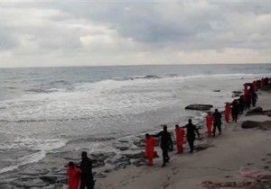 In this file image made from a video released Sunday, Feb. 15, 2015 by militants in Libya claiming loyalty to the Islamic State group purportedly shows Egyptian Coptic Christians in orange jumpsuits being led along a beach, each accompanied by a masked militant