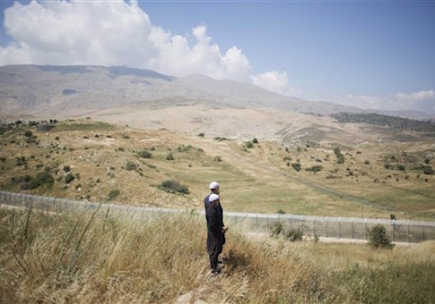 Members of Israel's Druze minority look at the the fighting between between forces loyal to Syrian President Bashar Assad and rebels in the Druze village of Khader in Syria, from the Israeli controlled Golan Heights, Tuesday, June 16, 2015