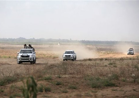 Hamas gunmen ride on the back of a pick-up truck as they patrol the border with Israel near the southern Gaza Strip town of Khan Younis