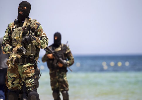 Tunisia's special forces secure the beachside of the Imperial Marhaba resort, while British, French, German and Tunisia's interior minister arrive to pay their tribute in front of a makeshift memorial in Sousse