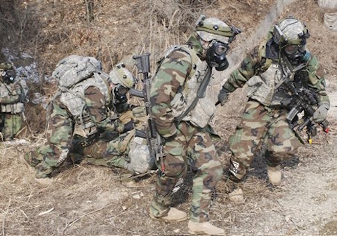 U.S. Soldiers wear gas masks as they extract a soldier during training.