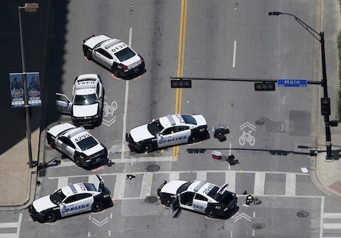Police cars remain parked with the pavement marked by spray paint, in an aerial view of the crime scene of a shooting attack in downtown Dallas