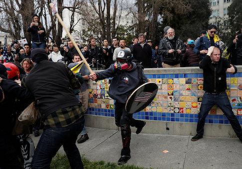 A demonstrator in support of U.S. President Donald Trump swings a stick towards a group of counter-protesters during a "People 4 Trump" rally in Berkeley, California