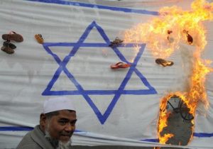 Pakistani activists torch an Israeli flag during a protest