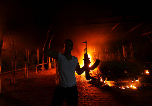 A protester reacts as the U.S. Consulate in Benghazi is seen in flames, September 11, 2012