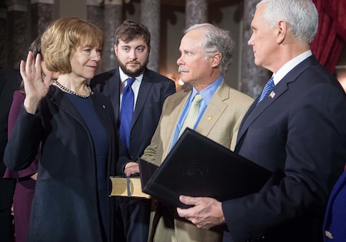 Sen. Tina Smith (L) is ceremonially sworn in by Vice President Mike Pence