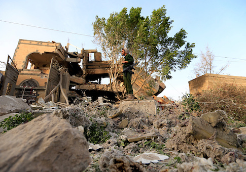 A Yemeni soldier stands in the rubble of a destroyed house in the aftermath of a reported air strike by the Saudi-led coalition in a neighborhood in Sanaa