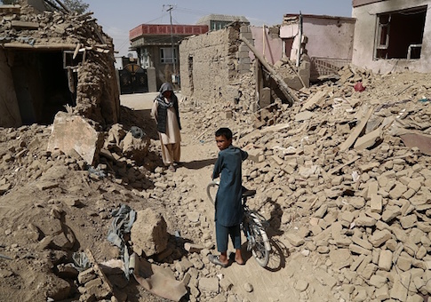 Afghan residents walk near destroyed houses after a Taliban attack in Ghazni