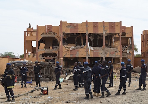 A Malian firefighters stand beside a destroyed building in Gao, after a suicide car bomb attack