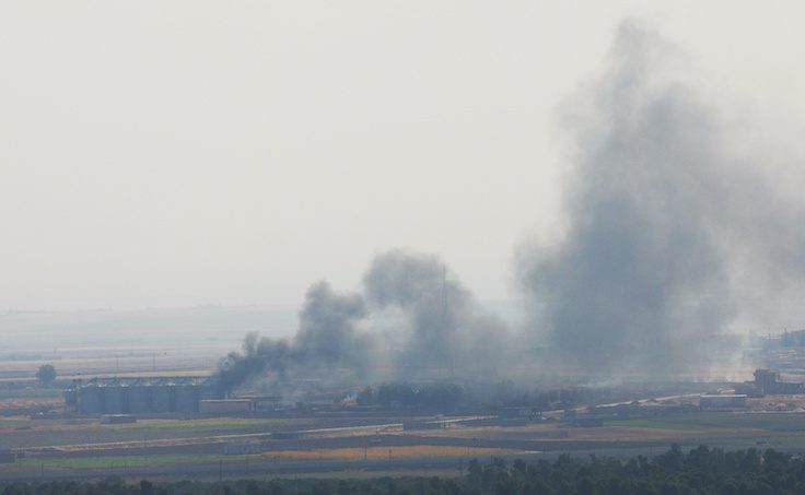 Smoke rises from a building near the Syrian town of Ras al-Ain as seen from the Turkish border town of Ceylanpinar