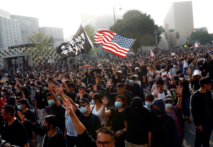 Anti-government protesters raise their hands as they attend the "Lest We Forget" rally in Hong Kong